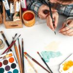 Akvarell festéshez szükséges eszközök asztalon, folyamatban lévő kép