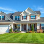 Modern amerikai családi ház zöld udvarral és garázzsal.