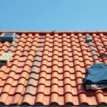 Tetőépítés cserepekkel, szakember a tetőn dolgozik