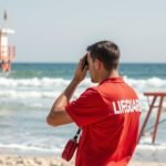 Úszómester a strandon, biztonsági intézkedéseket végez a vízparton.