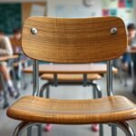 Iskolai szék a teremben, diákokkal a háttérben.