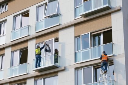 Panel ablakcserét végző szakemberek dolgoznak egy társasházon.