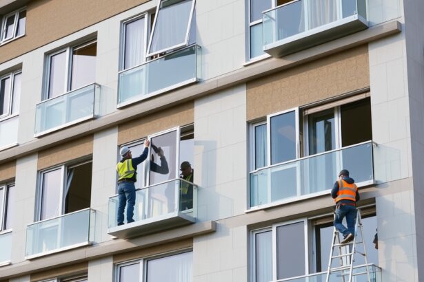 Panel ablakcserét végző szakemberek dolgoznak egy társasházon.