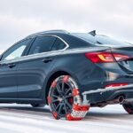 Autó hóláncokkal havas úton