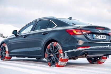 Autó hóláncokkal havas úton