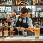 Férfi bartender koktél készítése egy modern bárban
