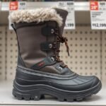 Téli bakancs a bolt polcán, szürke színben és bundás betéttel.
