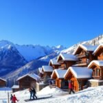 Téli hegyi üdülés festői tája síelőkkel és hegyi kunyhókkal